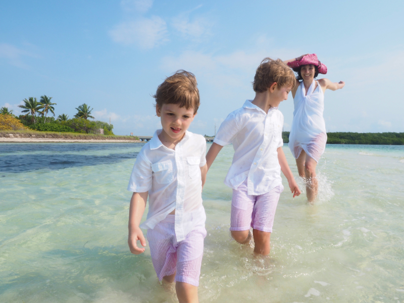 Mother And Boys Playing In Ocean